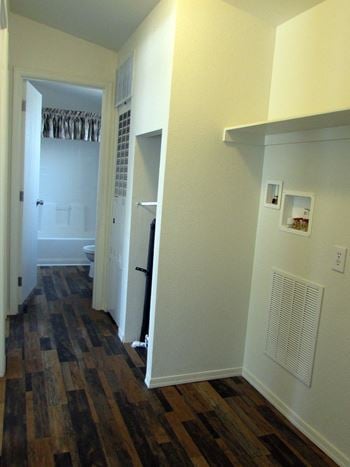 A bedroom with hardwood floors and white walls